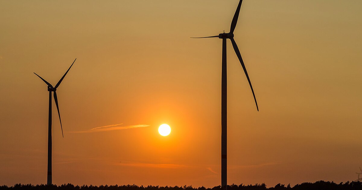 Onshore wind farm with orange sun in the background