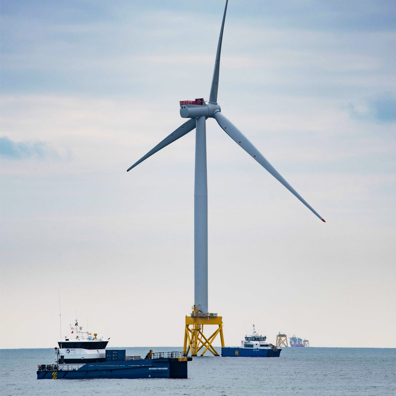 Offshore wind turbine with boat in foreground