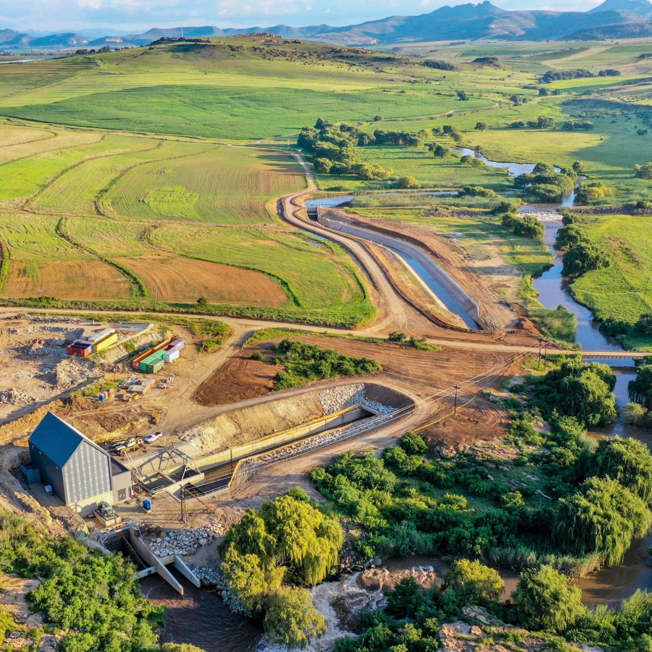 Hydro station and river among green field seen from the air