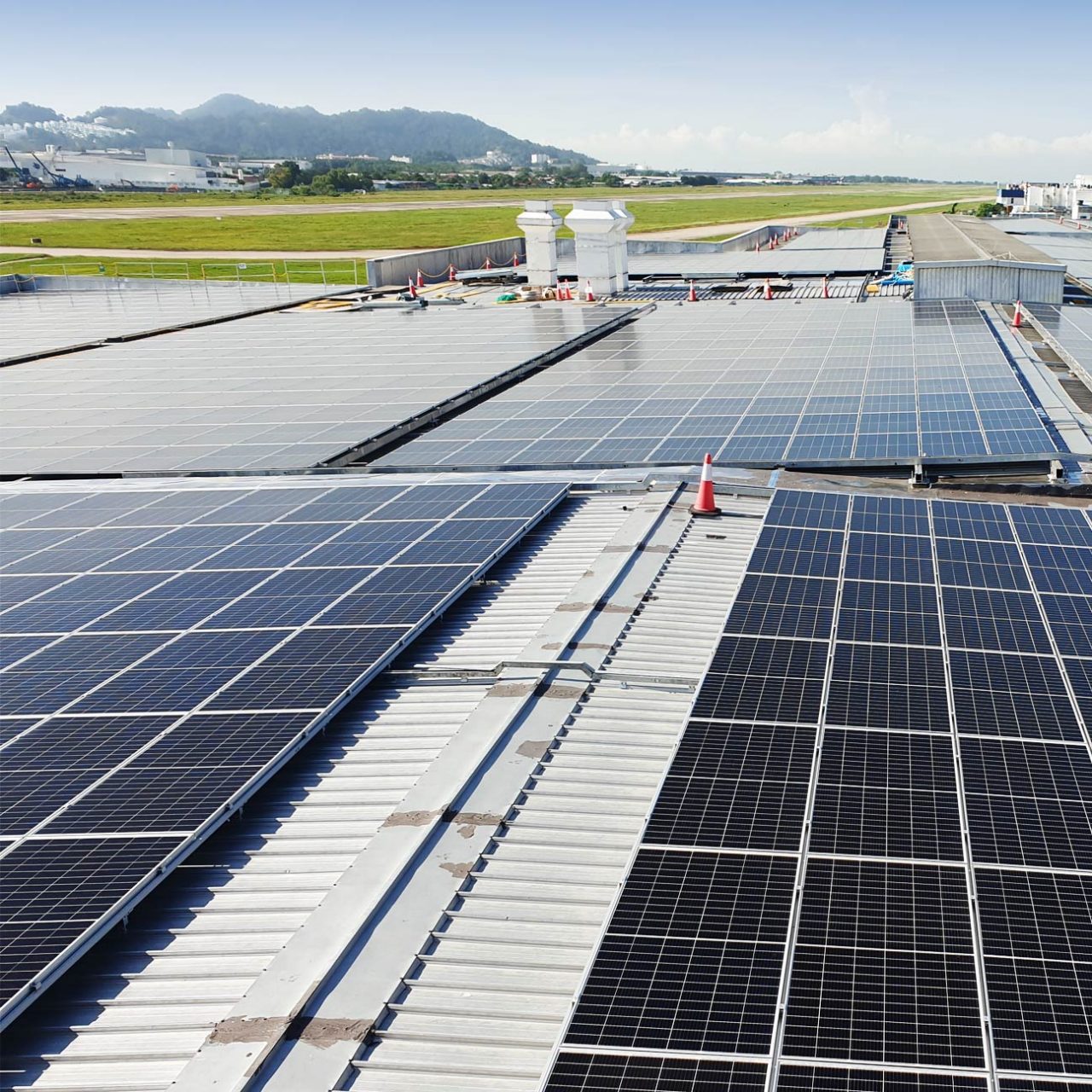 Solar panels on roof with fields and mountains in background