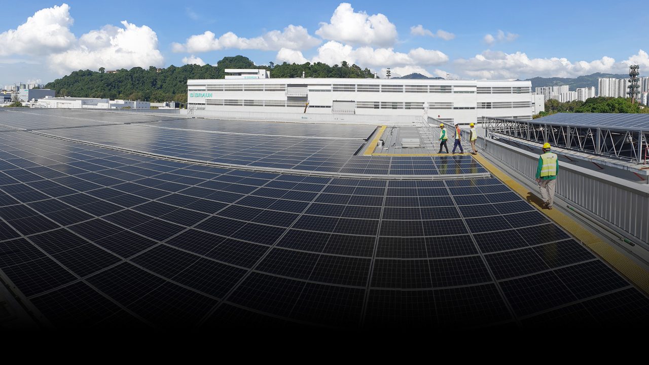 rooftop solar panels with workers in hardhat and high vis