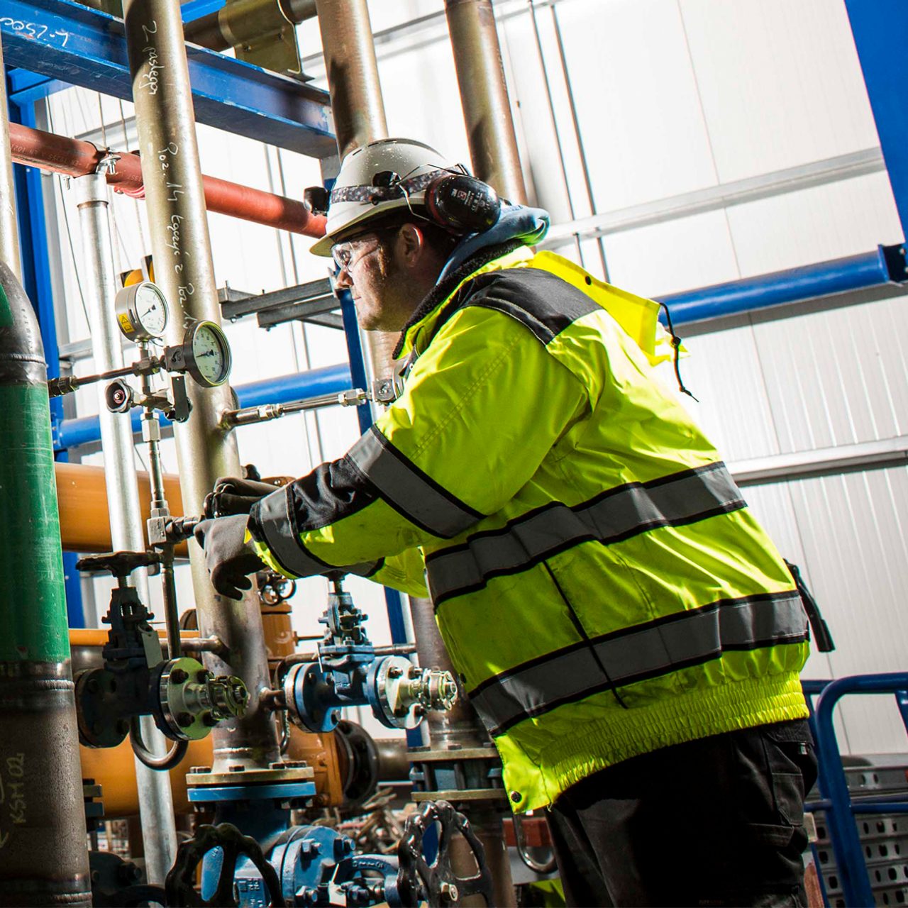 Worker monitors gauges in the plant