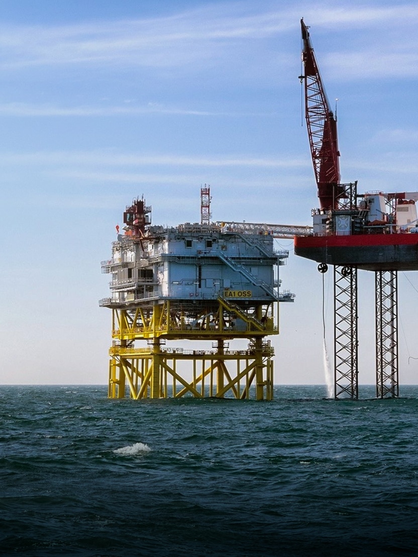 Offshore wind yellow and red turbine platforms in ocean