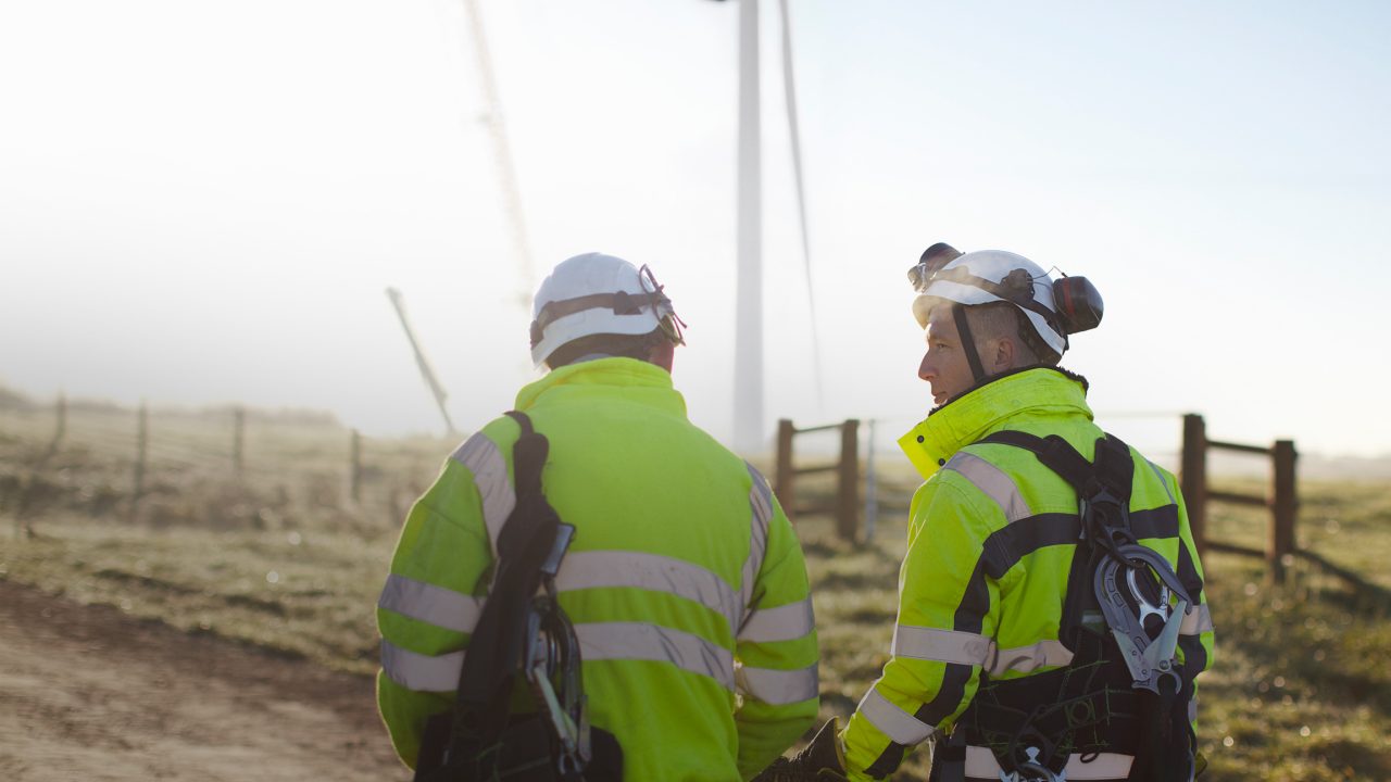 Two engineers at wind farm, walking together